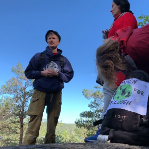 Gunaketu leading an interreligious climate pilgrimage with a priest and a sikh